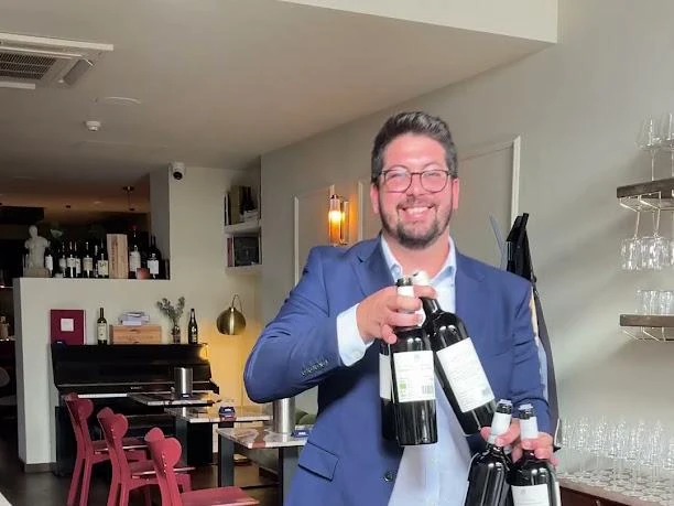 Un ospite presenta le bottiglie ai partecipanti della degustazione