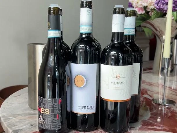 Tre bottiglie di Cantine Urso accanto al secchiello del ghiaccio