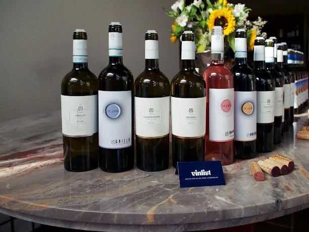 La selezione di vini Cantine Urso in primo piano sul tavolo di marmo